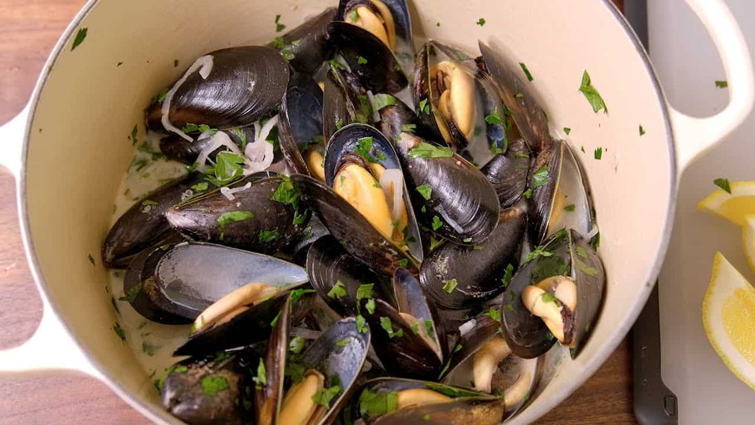 Pot of cooked muscles with herbs and red onions